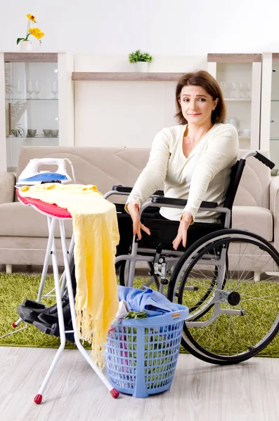 車椅子の女性が家でアイロンをかけ — ストック写真