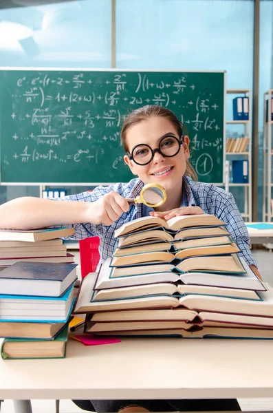 Női tanuló sok könyvet ül az osztályban — Stock Fotó