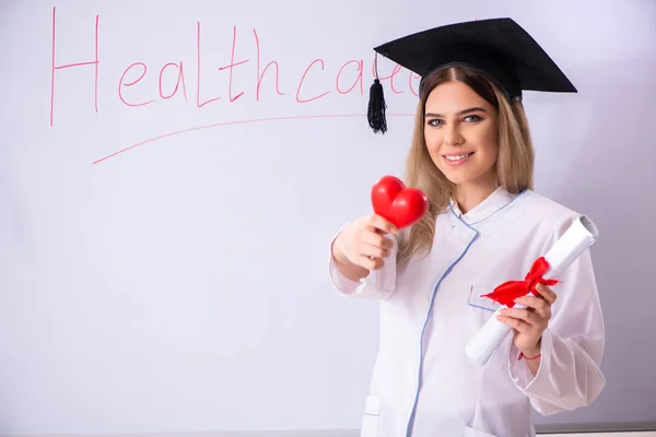 Doctora joven de pie frente a la pizarra blanca —  Fotos de Stock