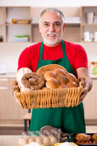 Starý muž baker práci v kuchyni — Stock fotografie