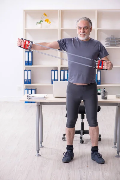 Blanc barbu vieil employé faire des exercices dans le bureau — Photo