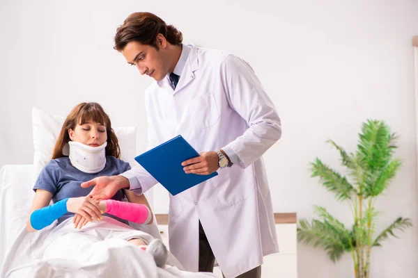 Jovem médico examinando paciente ferido — Fotografia de Stock