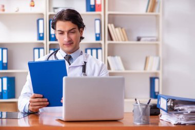 Klinikte çalışan yakışıklı genç bir doktor. 