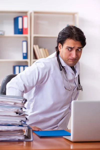 Jovem médico bonito que trabalha na clínica — Fotografia de Stock