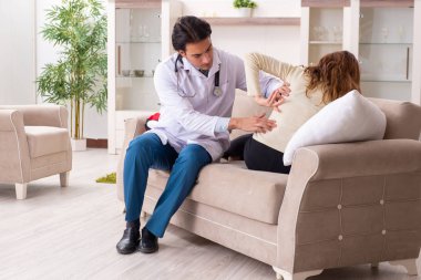 Genç, yakışıklı doktor, kadın hastayı evinde ziyaret ediyor. 