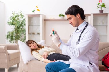 Genç, yakışıklı doktor, kadın hastayı evinde ziyaret ediyor. 