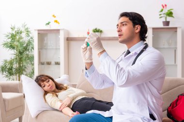 Genç, yakışıklı doktor, kadın hastayı evinde ziyaret ediyor. 