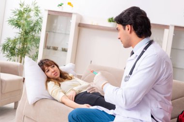 Genç, yakışıklı doktor, kadın hastayı evinde ziyaret ediyor. 
