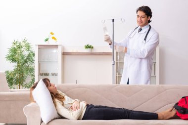 Genç, yakışıklı doktor, kadın hastayı evinde ziyaret ediyor. 