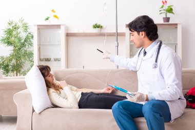 Genç, yakışıklı doktor, kadın hastayı evinde ziyaret ediyor. 