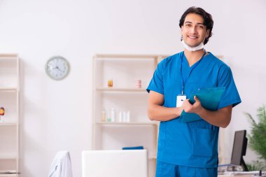 Klinikte çalışan yakışıklı genç bir doktor. 