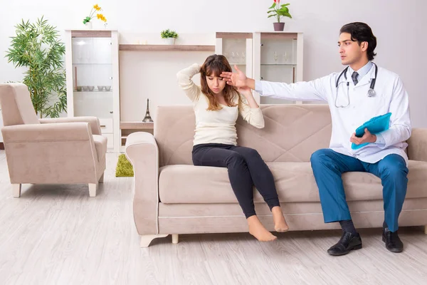 Giovane bel medico in visita paziente femminile a casa — Foto Stock