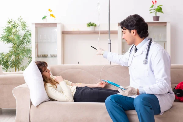 Genç, yakışıklı doktor, kadın hastayı evinde ziyaret ediyor. 