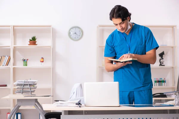 Mladý pohledný lékař pracující na klinice — Stock fotografie