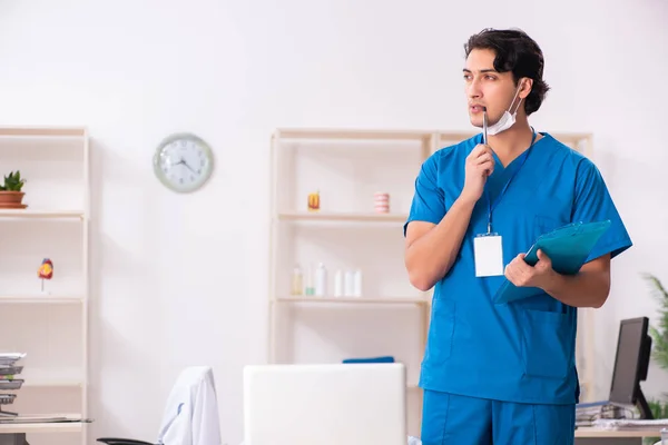 Joven médico guapo que trabaja en la clínica — Foto de Stock