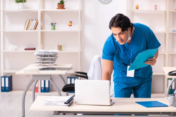 Joven médico guapo que trabaja en la clínica — Foto de Stock