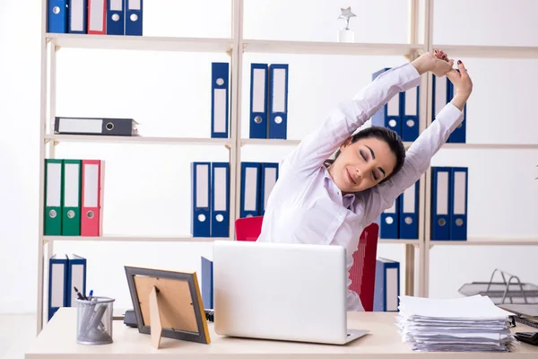 Junge Mitarbeiterin macht Übungen im Büro — Stockfoto