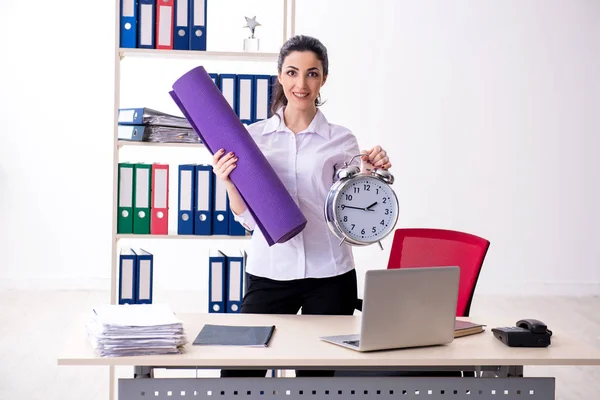 Young female employee doing exercises in the office