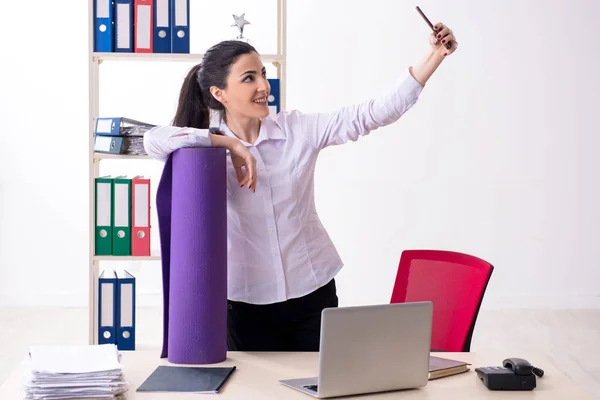 Junge Mitarbeiterin macht Übungen im Büro — Stockfoto