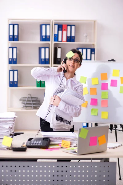 Young female employee in conflicting priorities concept