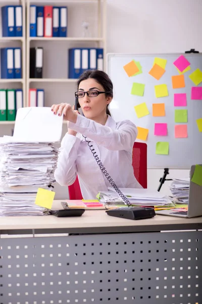 Young female employee in conflicting priorities concept