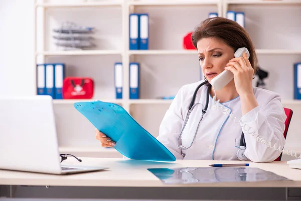 Verouderde vrouwelijke arts werkzaam in de kliniek — Stockfoto