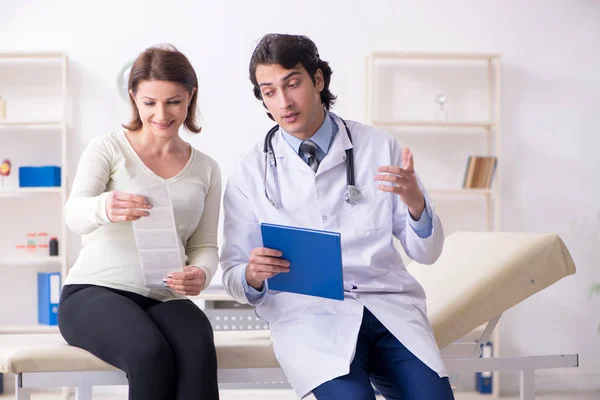 Gamla gravid kvinna besöker unga manliga läkare — Stockfoto