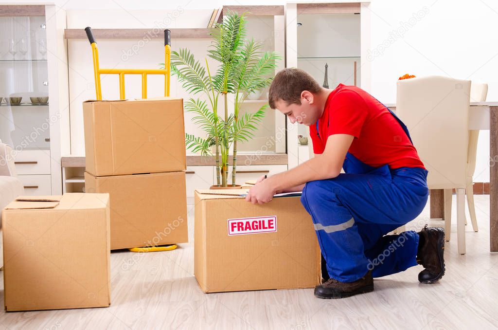 Young contractor with boxes working indoors 