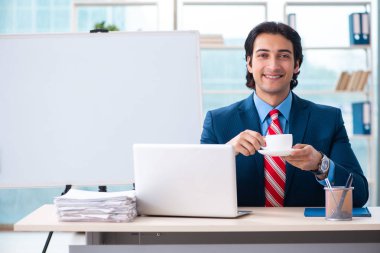 Genç yakışıklı iş adamı beyaz tahtanın önünde 