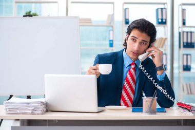 Genç yakışıklı iş adamı beyaz tahtanın önünde 