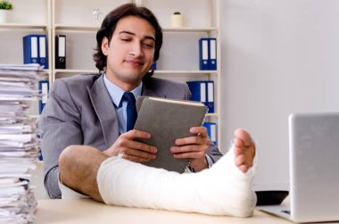 Ofiste çalışan bacağı yaralı bir çalışan. 