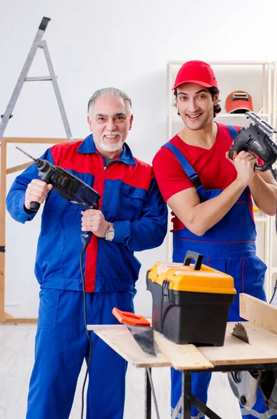 Dois empreiteiros profissionais que colocam piso em casa — Fotografia de Stock