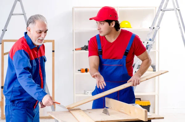 Two professional contractors laying flooring at home