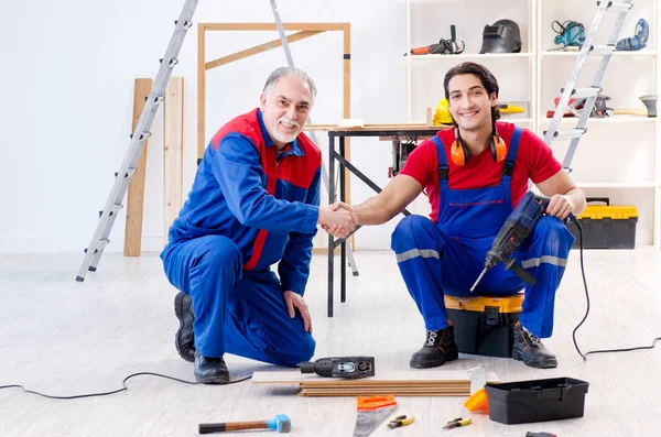 Two professional contractors laying flooring at home