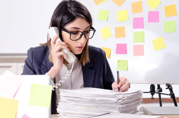 Joven empleada en el concepto de prioridades conflictivas — Foto de Stock