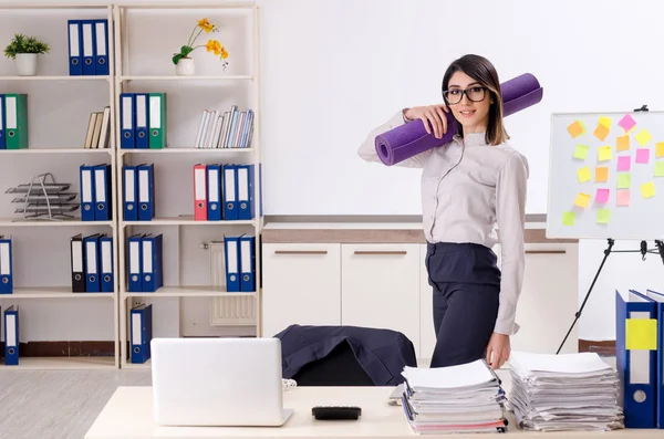 Giovane impiegata che fa esercizi sul posto di lavoro — Foto Stock