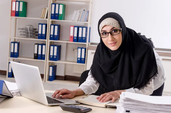 Kvinnlig anställd i hijab som arbetar på kontoret Stockbild