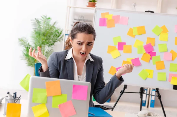 Joven empleada en el concepto de prioridades conflictivas — Foto de Stock