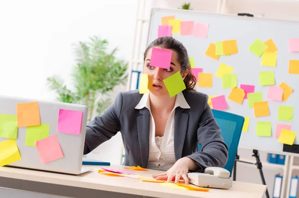 Young female employee in conflicting priorities concept — Stock Photo, Image