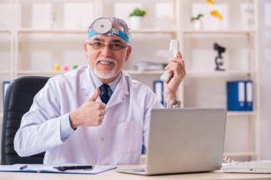 Klinikte çalışan yaşlı erkek doktor laryngologist 