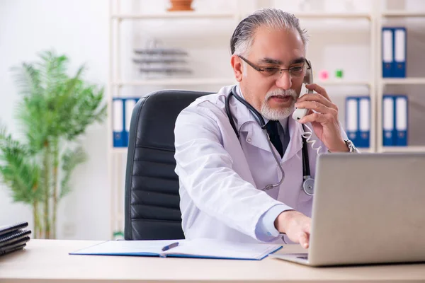 Ältere männliche Ärztin arbeitet in der Klinik — Stockfoto