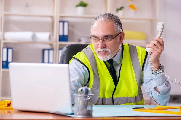 Betagter Bauingenieur arbeitet im Büro — Stockfoto