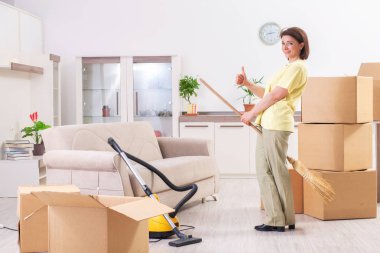 Middle-aged woman cleaning new apartment  clipart