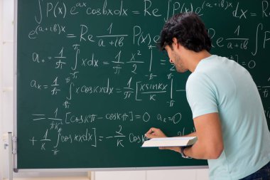 Kara tahta önünde genç erkek öğrenci matematikçi 