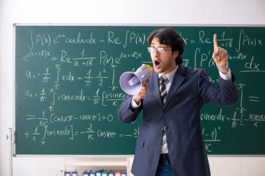 Genç erkek matematik öğretmeni sınıfta 