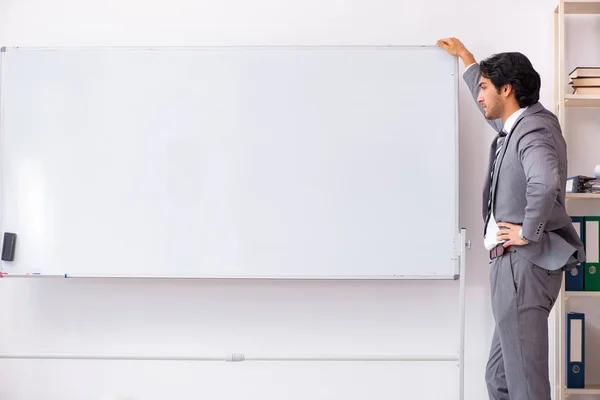 Jonge knappe zakenman staande voor whiteboard — Stockfoto