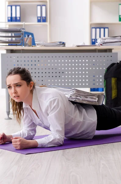 Female employee doing sport exercises in the office — Stock Photo, Image