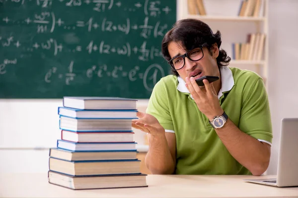 Handsome student in front of chalkboard with formulas — Stock Photo, Image