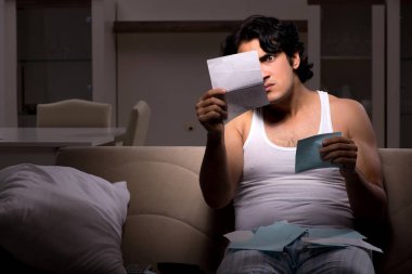 Genç adam masraflar gece evde hesaplama 