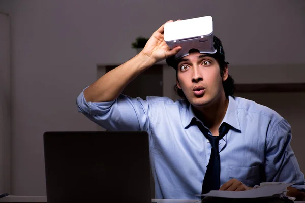 Junger Angestellter mit virtueller Brille nachts im Büro — Stockfoto